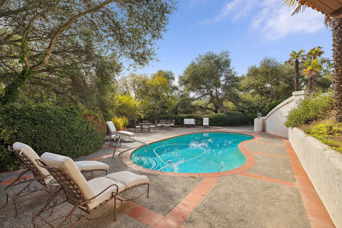 The estate from the approach, palms lining the motor court.